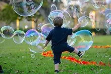 Cute_little_boy_playing_amongst_the_Giant_Bubbles.webp